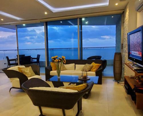 a living room with a couch and chairs and a television at Amplio 140m2 Grand Diamond Tonsupa in Tonsupa