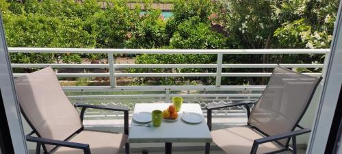two chairs and a table on a balcony at Evelin hotel in Pythagoreio