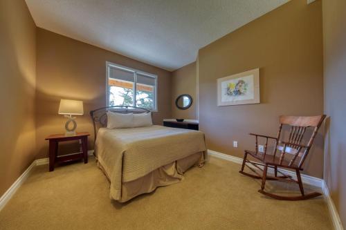 a bedroom with a bed and a chair and a window at Marble Canyon in Fairmont Hot Springs