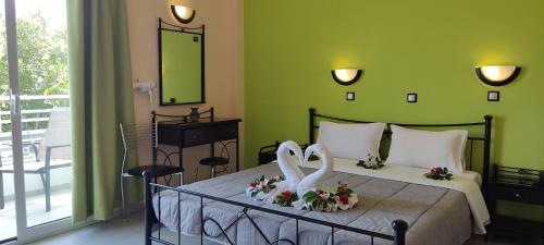 a bedroom with a bed with two swans on it at Evelin hotel in Pythagoreio