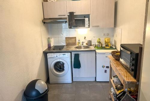 uma pequena cozinha com uma máquina de lavar roupa e um lavatório em Joli appartement T2 em Montpellier