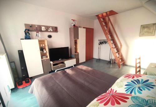 Schlafzimmer mit einem Bett, einem TV und einer Leiter in der Unterkunft Wohnung auf 2 Ebenen in Leopoldshöhe