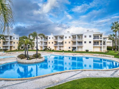 a large swimming pool in front of apartment buildings at Close to beach Alvor 1 bedroom apartment Villa da Praia AT08 in Alvor