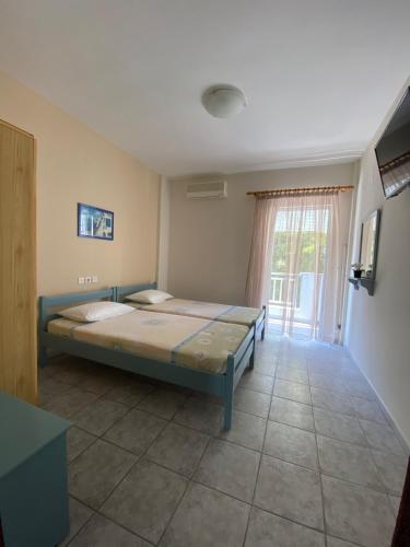 a bedroom with a bed and a large window at Villa Ilias in Olympiaki Akti