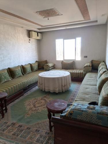 sala de estar con sofá y mesa en RÉSIDENCE YANISS, en Marrakech