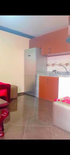 a kitchen with a stainless steel refrigerator and brown cabinets at Hay Mohammadi agadir in Agadir