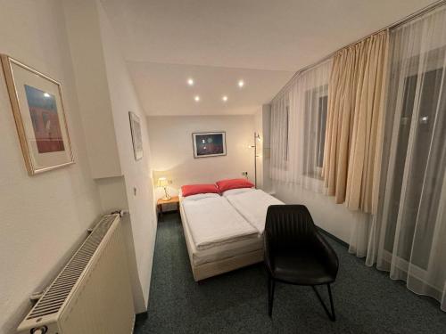 Habitación de hotel con cama y silla en Hotel Occam en Múnich