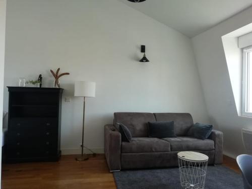 ein Wohnzimmer mit einem Sofa und einem Tisch in der Unterkunft Les suites de la villa Margaux in Bezons