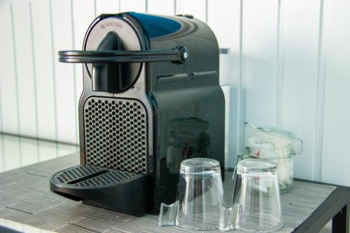 a coffee maker sitting on a table with two glasses at B&B LIBRA rooms & suite in Salerno