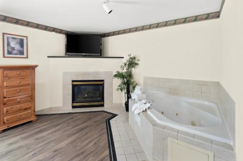 a living room with a tub and a fireplace at GuestHouse Inn & Suites Kelso/Longview in Kelso