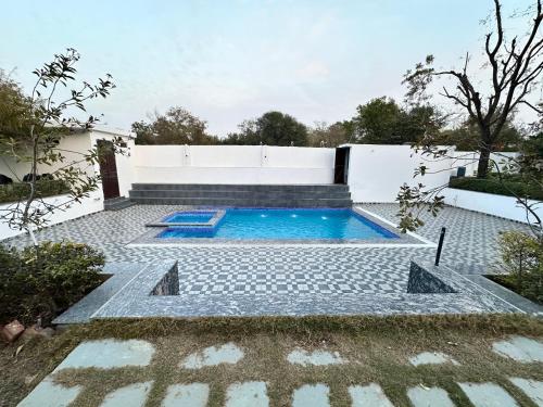 a swimming pool in the backyard of a house at Namastay farm in Jaipur