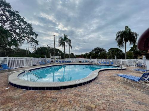 a large swimming pool with chairs at Stylish and Modern Shorewalk condo close to top beaches, heated pools, hot tub, IMG Academy, dining in Bradenton