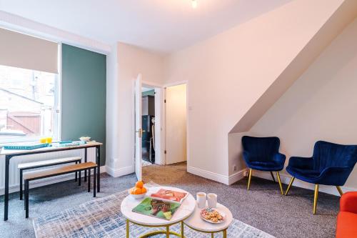 uma sala de estar com um piano e cadeiras azuis em Charming 3-Bedroom House-Salford em Manchester