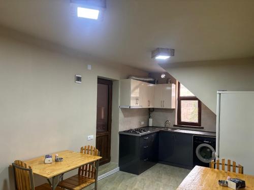 a kitchen with a wooden table and a table and chairs at LUCY B&B in Garni