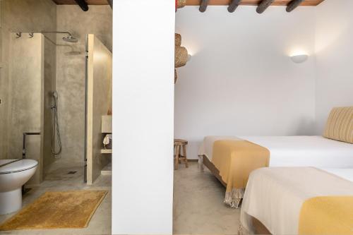 2 imágenes de un dormitorio con 2 camas y ducha en Santa Paciência Reguengos de Monsaraz, en Reguengos de Monsaraz