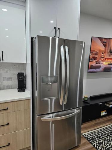a stainless steel refrigerator in a kitchen at Cozy 2 bedrooms and 1 bath for 4 guests! in Calgary