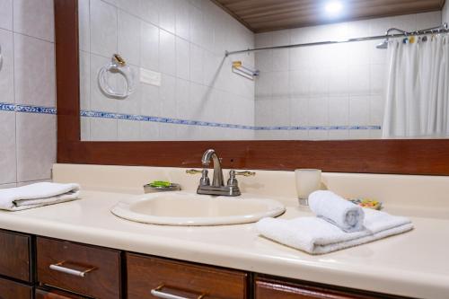 y baño con lavabo y espejo. en Family 2bd apt near Quepos/Manuel Antonio, en Quepos