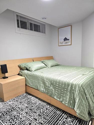 a bedroom with a large bed and a night stand at Cozy 2 bedrooms and 1 bath for 4 guests! in Calgary