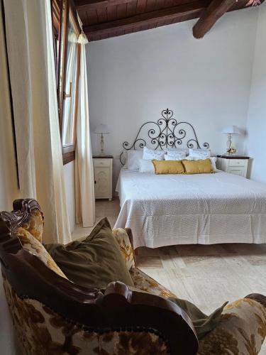 a bedroom with a bed and a chair in a room at Belvedere Country House in Enas