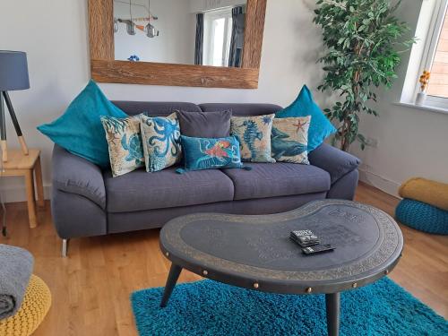 a living room with a purple couch with blue pillows at Fistral beach apartment in Newquay