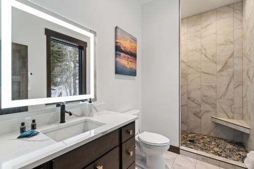 a bathroom with a sink and a toilet and a mirror at Latitude Adjustment in Whitefish