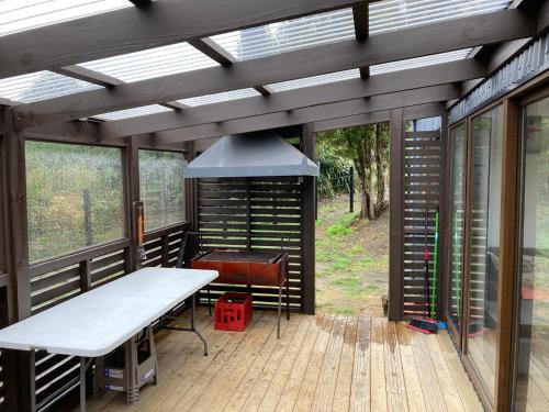 a screened in porch with a table and a grill at Cabañas Casatur para 6 personas en Ancud Chiloe in Ancud