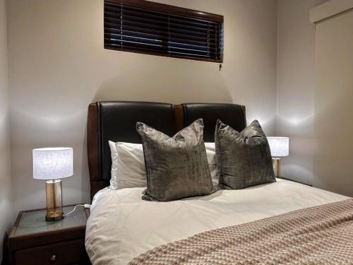 a bedroom with a bed with a black headboard and pillows at Resort Retreat, Private Suite, Zimbali Estate in Ballito