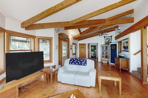 a living room with a white couch and a tv at Horizon's End in Islandale