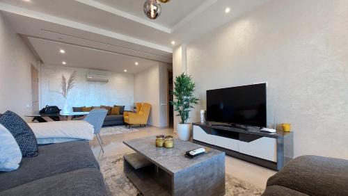 uma sala de estar com um sofá e uma televisão em Luxury F3 appartment Les Orangers em Marrakech