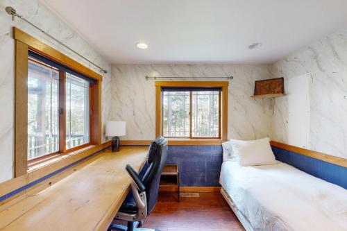 a bedroom with a bed and a desk and a bed and window at Horizon's End in Islandale