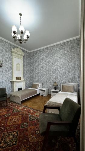 a bedroom with two beds and a chair and a rug at Vintage Boutique Hostel in Baku