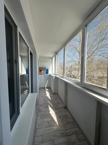 a hallway with two windows and a floor with a hallwayngth at Назарбаева 204 in Pavlodar