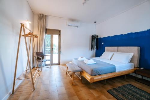 a bedroom with a bed and a blue wall at Apollonas & Sibylla Villa - Luxury Stay with Pool in Kalymnos