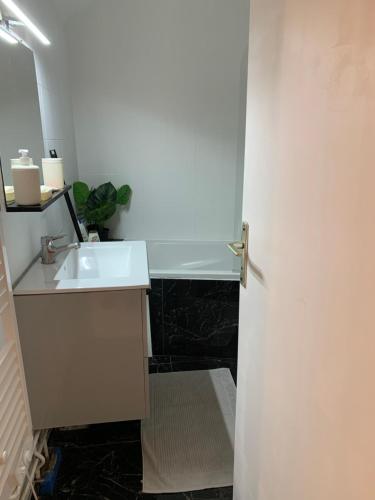 une salle de bain avec un lavabo et un miroir dans l'établissement KIFKIF entrée autonome boîte à clef, à Saint-Germain-lès-Arpajon