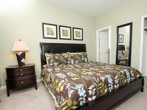 a bedroom with a bed and a table with a lamp at Comrow Villa 7739 in Orlando