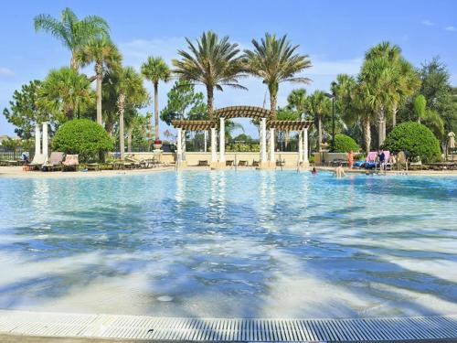 a large swimming pool with a gazebo and palm trees at Comrow Villa 7739 in Orlando