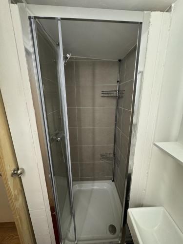 a shower with a glass door in a bathroom at Duplex Studio 3 minute drive from Luton airport in Luton