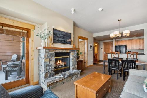 a living room with a fireplace and a kitchen at Morning Eagle 207 in Whitefish