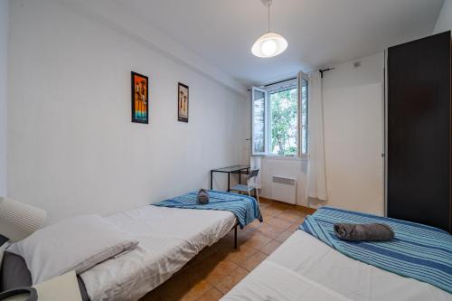 a bedroom with two beds and a window at 3 pièces, hyper-centre, terrasse in Nice