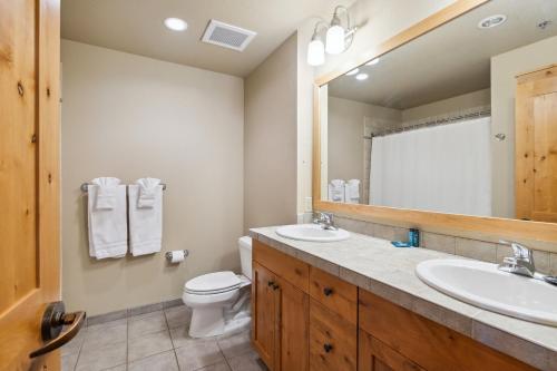 bagno con lavandino, servizi igienici e specchio di Morning Eagle 209 a Whitefish