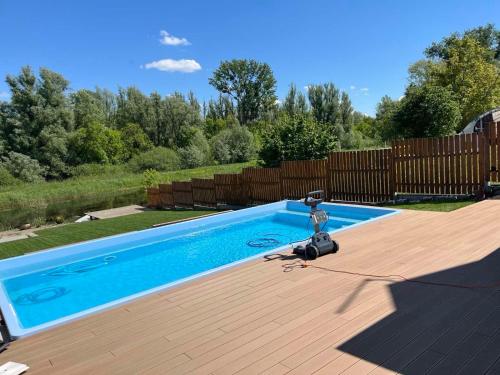 a swimming pool on a wooden deck next to a fence at Kuća za odmor GUSKA in Kopačevo