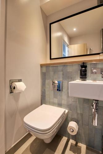 a bathroom with a toilet and a sink and a mirror at President Hotel in London