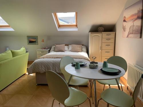 een slaapkamer met een bed en een tafel en stoelen bij Studio 11 in Ballymoney