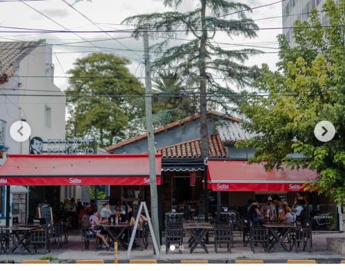 un grupo de personas sentadas en las mesas fuera de un restaurante en Departamento Bambú Salta Capital en Salta