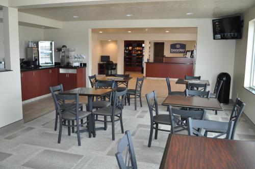 a dining room with tables and chairs in a restaurant at Boarders Inn & Suites by Cobblestone Hotels - Broken Bow in Broken Bow