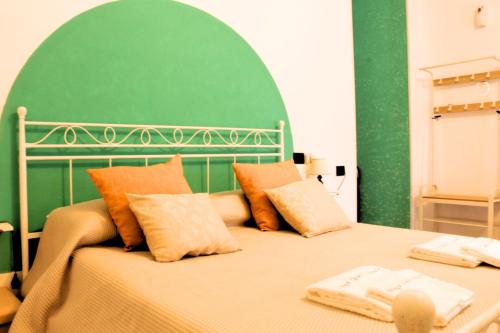 um quarto com uma cama grande e uma parede verde em Maya guest house em Vietri