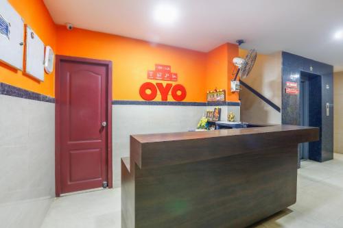 a kitchen with an orange wall and a red door at Collection O Mamieyaar Veedu in Chennai