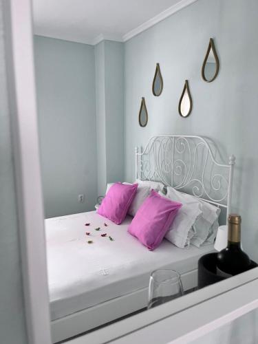 a bedroom with a white bed with pink pillows at Zoel's House in Chalkidiki in Agia Paraskevi