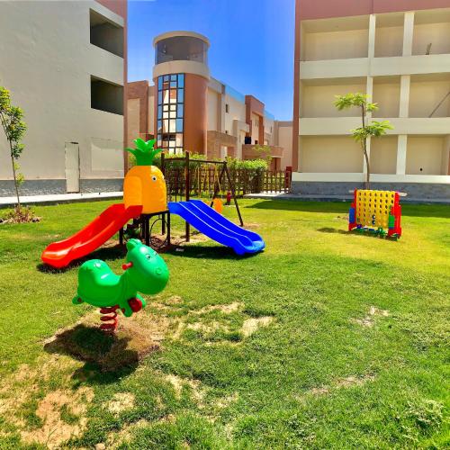 um parque infantil com um escorrega na relva em شاليه فندقى داخل فندق هلنان بورفؤاد Private Apartment Inside Helnan Hotel Port Fouad em Port Said