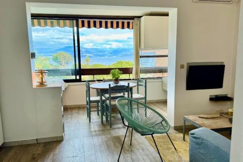 un salon avec une table et des chaises et une fenêtre dans l'établissement Charming 37 m nest near the sea, à Ajaccio